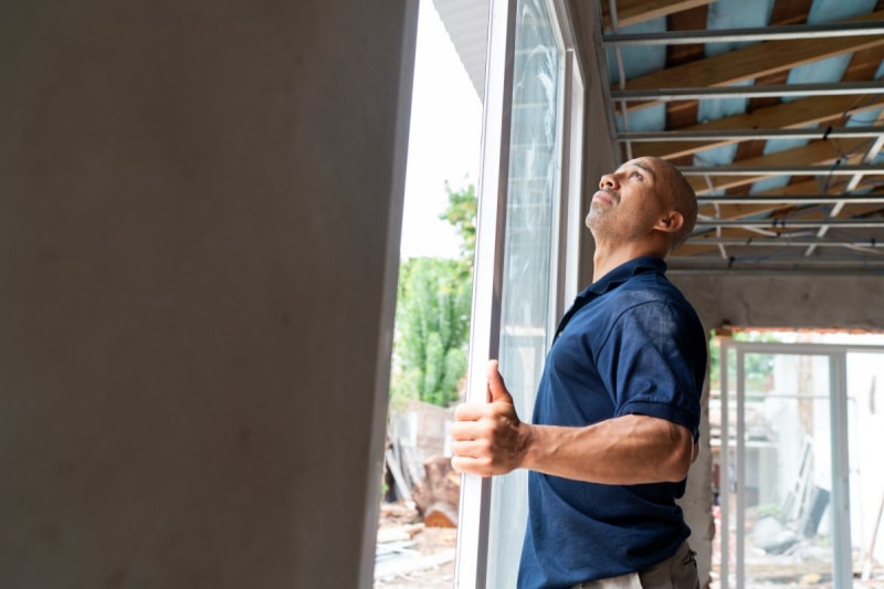 Ouvrier du bâtiment installant une nouvelle fenêtre.