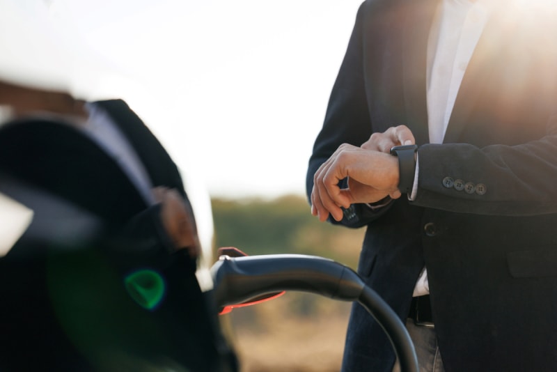 Les coûts cachés de la possession d'une voiture électrique - un homme regarde sa montre