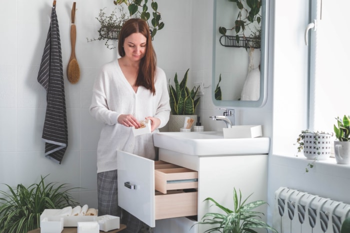 Femme organisant le rangement de la salle de bain.