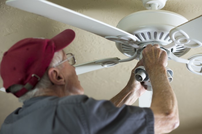 iStock-1300884252 winterize your rental man adjusting ceiling fan direction.jpg