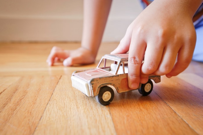 Enfant jouant avec une voiture en métal