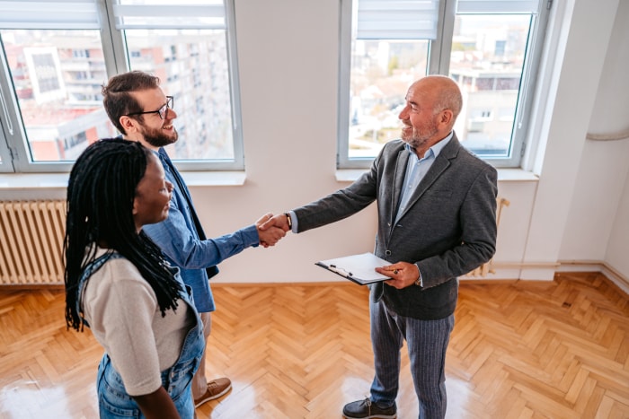 propriétaire parlant à un couple louant un appartement