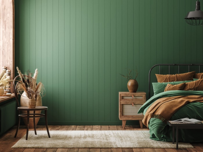 une-chambre-à-coucher-vert-et-tan-avec-des-accents-en-écosse-et-rotin-vert