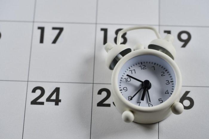 heure d'été 2023 - horloge posée sur un calendrier papier