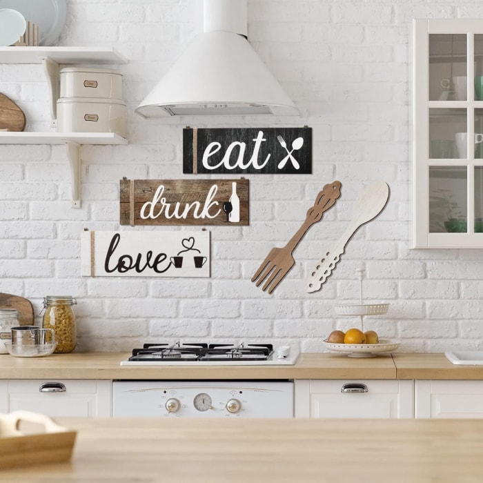 Cuisine blanche avec trois grandes pancartes sur le mur.