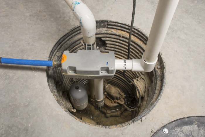 Une pompe de puisard installée dans un sous-sol d’une maison avec un système de secours alimenté par l’eau.