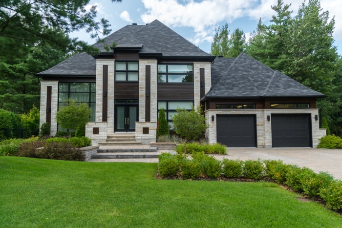 grande maison de luxe extérieure en pierre blanche et lambris en bois foncé