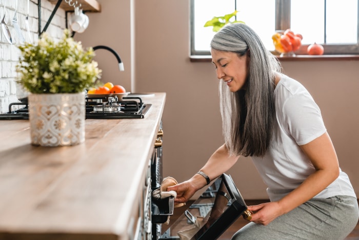 Belle femme caucasienne mature en train de cuire au four dans la cuisine