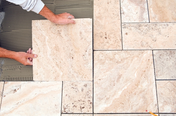 Pose de carrelage en pierre naturelle dans une salle de bain