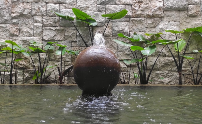 Fontaine en forme de boule sur la piscine du jardin de la maison pendant la journée ensoleillée