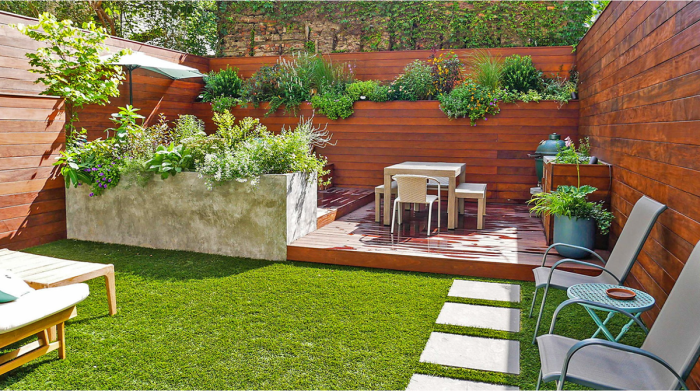 terrasse extérieure avec grand mur en bois comportant de hautes jardinières profondes avec des plantes luxuriantes