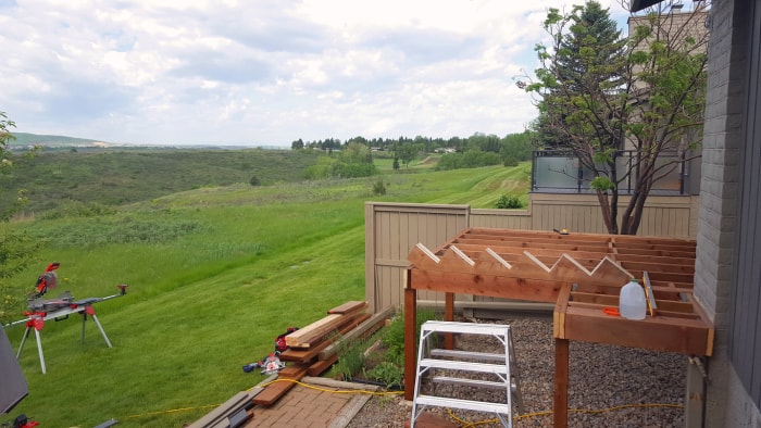 terrasse partiellement construite à côté d'une maison grise dans une vallée verdoyante