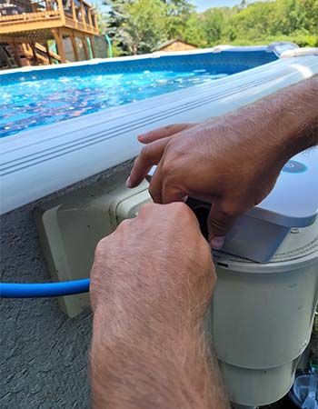 Une personne installant l'adaptateur secteur du robot nettoyeur de piscine Dolphin Escape