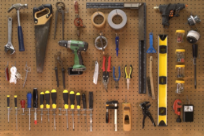 collection d'outils de travail dans un atelier montés sur un panneau mural