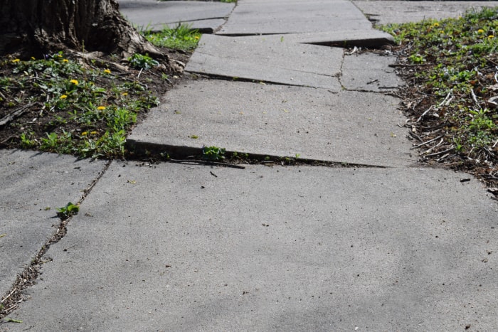 trottoir et allée en béton gravement fissurés