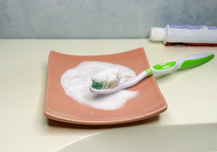 Nettoyage des dents avec une brosse à dents et du bicarbonate de soude