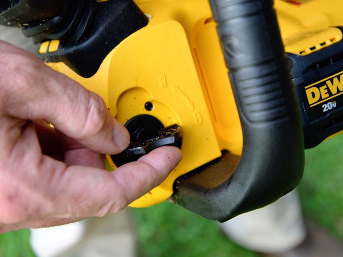 Personne utilisant un cadran pour déverrouiller la tronçonneuse DeWalt 20V