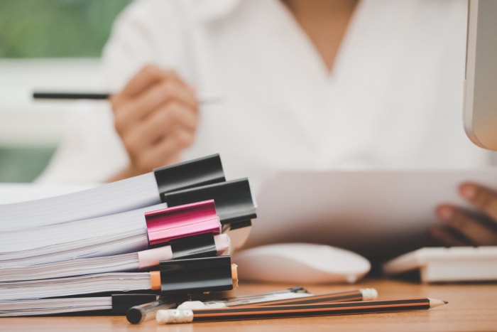 Piles de documents découpés avec une femme en arrière-plan