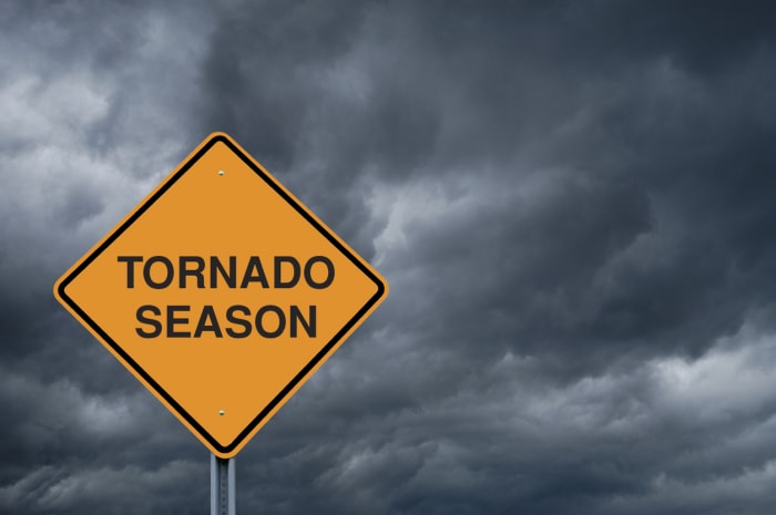 Panneau de signalisation « Saison des tornades » sur fond de nuages sombres et menaçants.