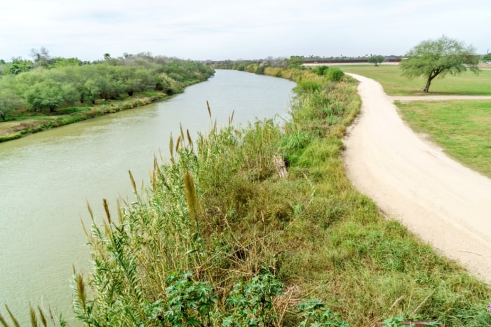 Paysage herbeux avec promenade le long de la rivière.