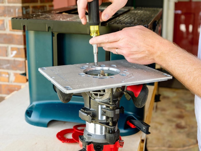 Une personne ajustant la table de toupie sur le Bosch Benchtop RA1181 pendant les tests.