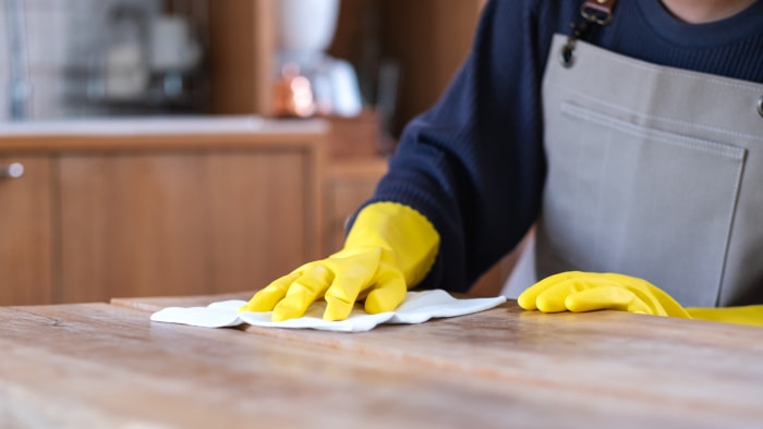 comptoirs de boucher mains gantées essuyant le comptoir avec un chiffon doux