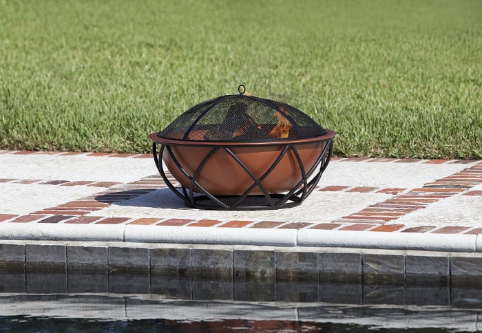 La meilleure option de foyer en cuivre avec un feu brûlant à proximité du bord d'une piscine