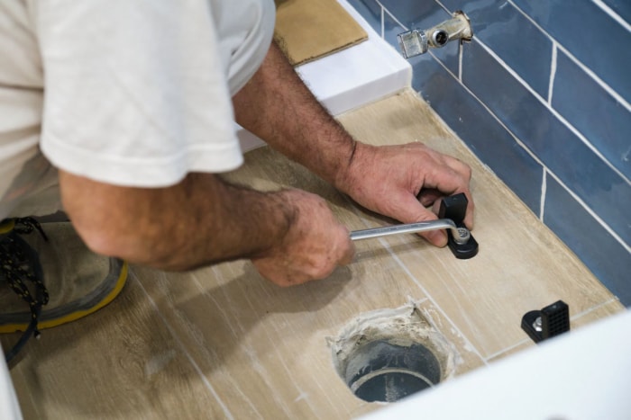 Combien coûte le remplacement d'une bride de toilette : plombier expert effectuant un remplacement de bride de toilette