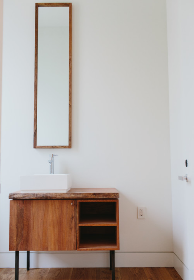 Miroir de salle de bains long et étroit au-dessus d'un lavabo carré