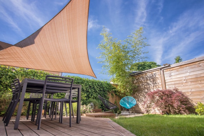 Terrasse d'une maison moderne en été avec table et parasols