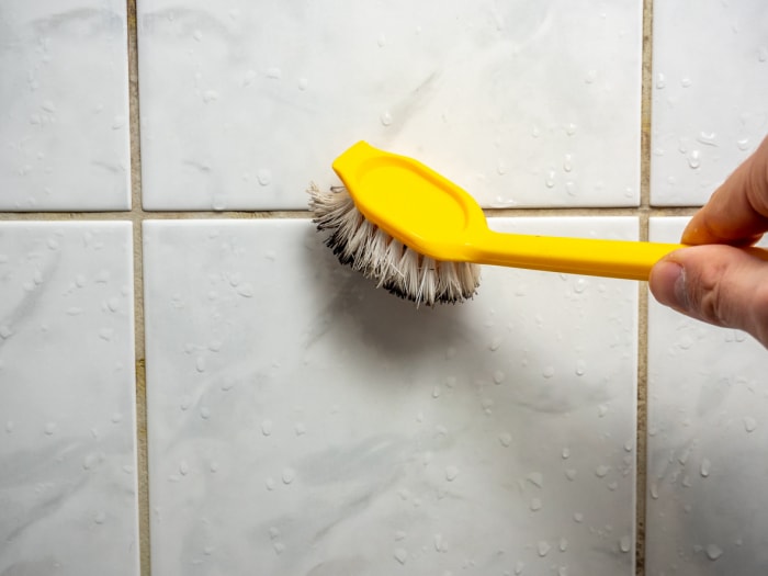 comment utiliser oxiclean nettoyer les taches de coulis dans la salle de bain avec une brosse