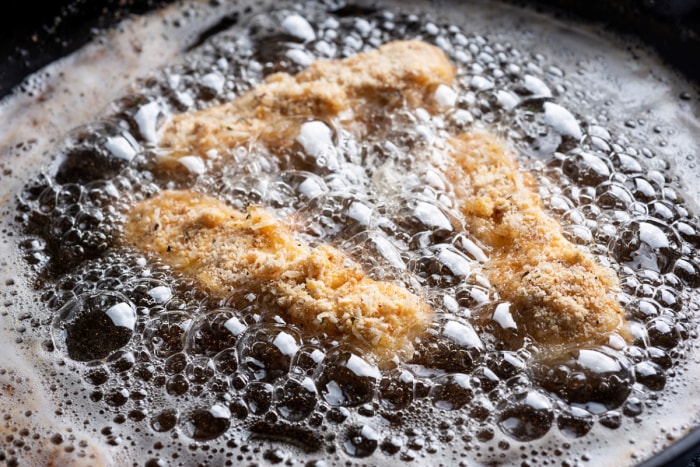 Aliments en train de frire dans une poêle.