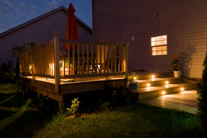 Terrasse en bois et patio de la maison familiale la nuit.