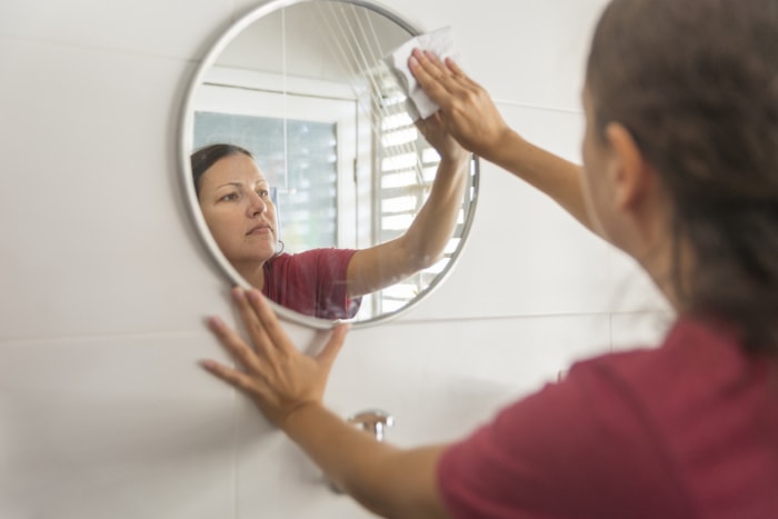 femme essuyant le miroir