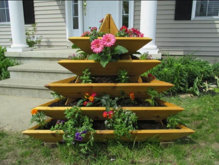 jardin en bois en forme de pyramide avec des plantes en pot dans la cour avant