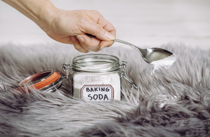 iStock-1218545906 enlever la crasse des tapis et des rideaux en mettant du bicarbonate de soude sur le tapis.jpg