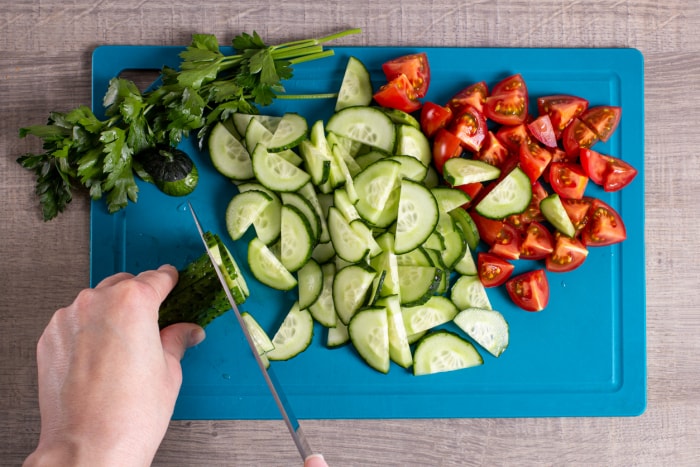 iStock-1322887287 économiser de l'argent jardinage frais généraux d'une femme coupant des concombres et des tomates