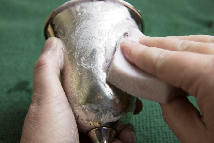 Polissage d'une tasse en argent.