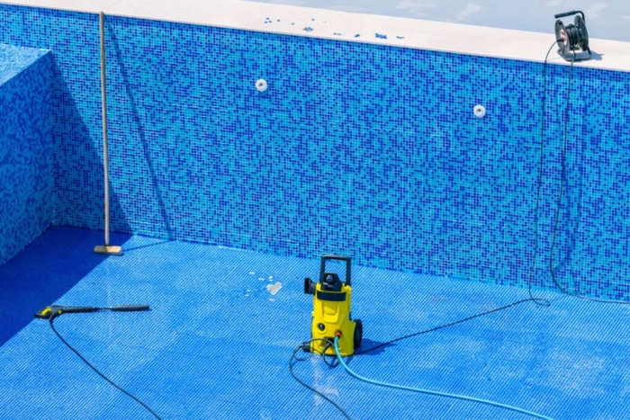 Gros plan sur un nettoyeur de piscine dans une piscine vidée.