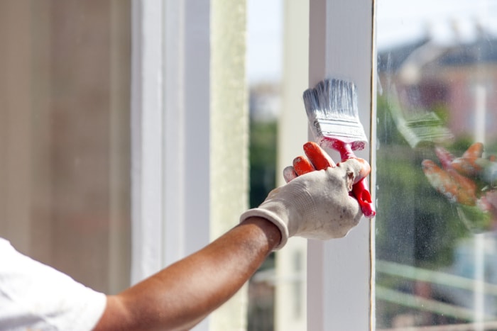 Peinture d'un rebord de fenêtre intérieur en blanc.