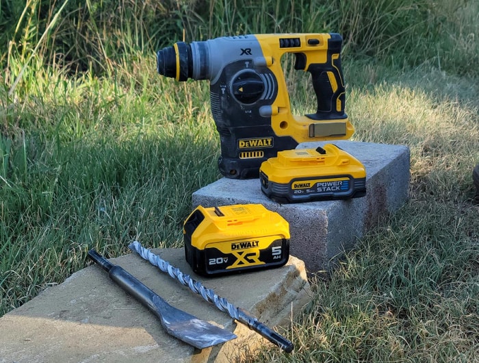 Batteries DeWalt PowerStack sur un bloc de béton à côté d'une perceuse à béton DeWalt