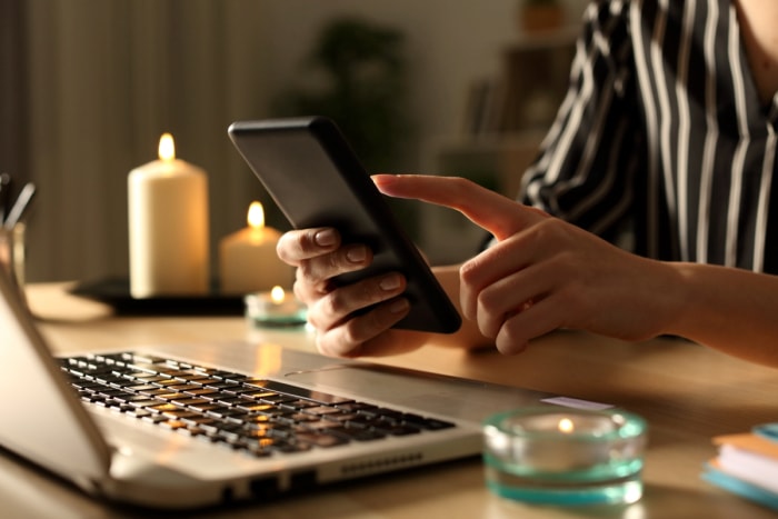 Une femme compose un numéro de téléphone dans le noir