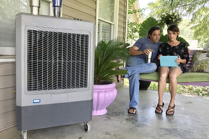 La meilleure option de refroidisseur d'air évaporatif sur un porche près de deux personnes assises sur une balançoire de porche