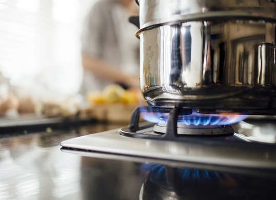 gros plan d'un brûleur à gaz et d'une casserole sur la cuisinière