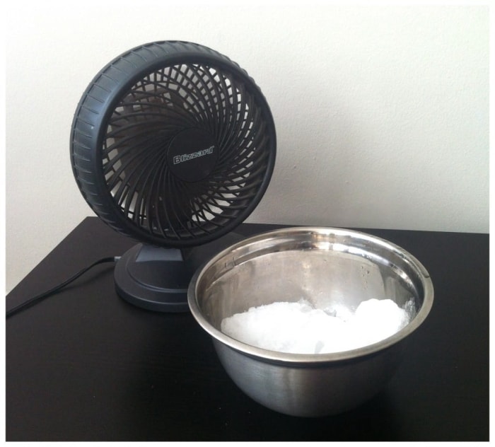 Ventilateur sur une table avec un bol de glace sur la table