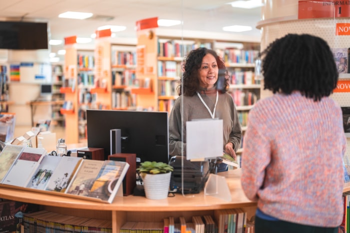 iStock-1455947949 économiser de l'argent jardiner lati femme bibliothécaire aider un usager