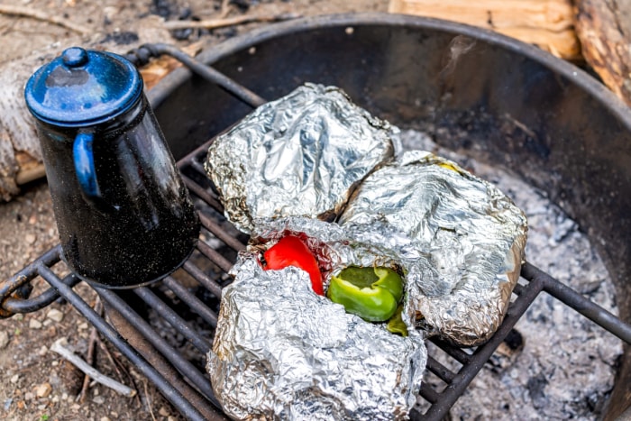 Des aliments recouverts de papier d'aluminium cuisent dans un foyer