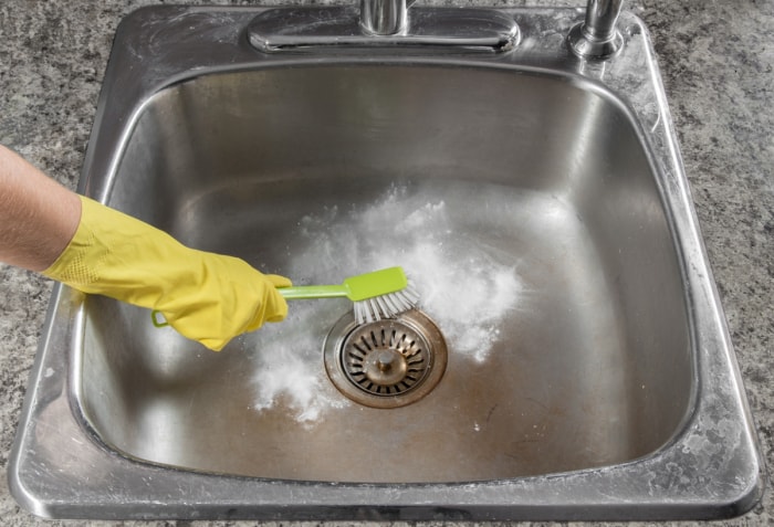 Brosse à récurer l'évier de cuisine avec un nettoyant en poudre