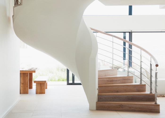 Un grand escalier incurvé dans une maison moderne à aire ouverte.