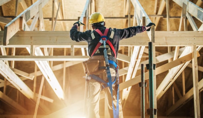 Un ouvrier du bâtiment travaille dans une maison en construction.